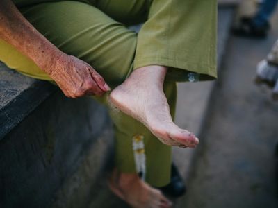 Close-up of hands resting on knees in a sitting pose.